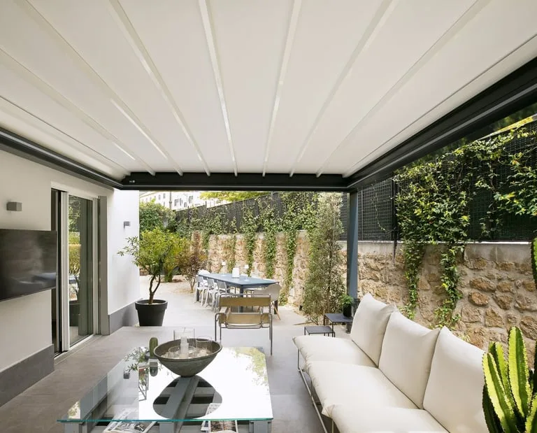 Pergola à toit rétractable ouverte au-dessus d'un salon extérieur